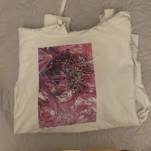 Hoodie med tryck - Vit hoodie med ett rosa tryck fram, fint skick, inga defekter eller skador, säljer pågrund av att tröjan inte kommer till användning 🩷