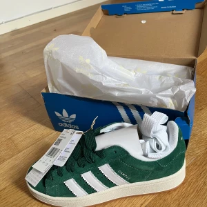 Gröna Adidas Campus 00s sneakers - Säljer ett par helt nya mörkgröna Adidas Campus 00s sneakers i strl 38. De kommer i originalförpackning och är i nyskick. Perfekta för både vardag och fest! Säljer då jag råka beställa två par exakt likadana. Extra skosnören och orginalförpackning medföljes! 😊