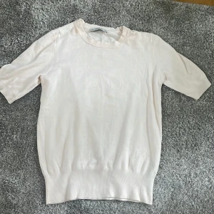 Vit stickad tröja från Zara - Säljer en vit stickad tröja från Zara i storlek S. Tröjan är kortärmad och har en normal passform. Perfekt för både vår och sommar! Den är i nyskick och väldigt bekväm att ha på sig. Passar bra till både jeans och kjol. 🌸