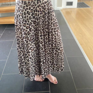Leopardmönstrad kjol från H&M - Säljer en superfin leopardmönstrad kjol från H&M i storlek XS (EUR 34). Kjolen är lång och har en lös passform, perfekt för både vardag och fest. Materialet känns mjukt och skönt mot huden. Den är i nyskick och har knappt använts. Passa på att köpa denna trendiga kjol! 🐆