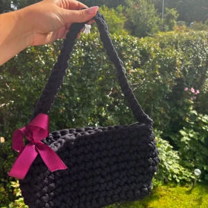 Handgjord väska - Virkad väska som jag gjort själv. Rosetten går att ta av om man vill det. Gjord i återvunnet garn.❤️  Väskan är ca 33 cm bred och ca 17 cm djup. Bandet är ca 55 vem långt.  300kr + fraktkostnad 