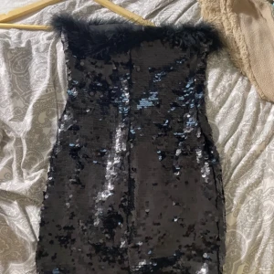 Mini klänning  - En mini klänning som inte har armar, den har lite puff grejer där uppe och har massa paljetter, den är i jättebra skick då den knappt är använd 