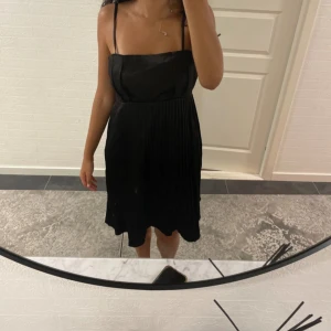 En svart klänning  - En snygg svart klänning med snyggt mönster på kjolen, bra skick