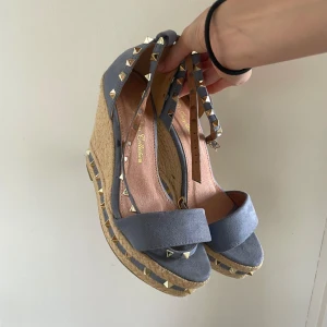 Ljusblåa somriga klackskor  - Drömmiga ljusblåa mockaklackar med nitar på sidorna & på banden som man knyter runt benet. De är från ”JessyBossCollections”, storlek 38. Passar så bra till kjol eller klänning och säljer pga råkat köpa i fel storlek. Tar gärna emot nya prisförslag💘