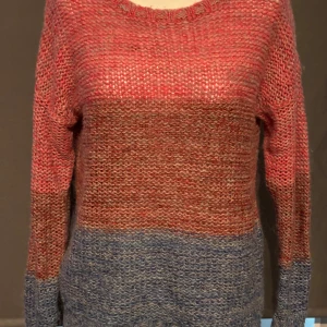 Röd och grå stickad tröja från Cubus - Säljer en mysig stickad tröja från Cubus i storlek S. Tröjan har en fin färgblockdesign med röd upptill och grå/blå nedtill. Den är perfekt för höst och vinter med sin varma och bekväma känsla. Tröjan har långa ärmar och en rund halsringning. Perfekt för att hålla sig varm och snygg under de kallare månaderna!