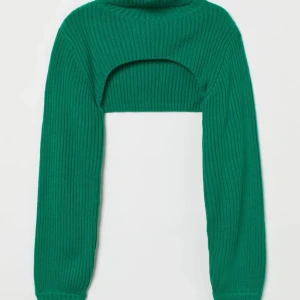 Grön ribbad stickad tröja - Säljer en grön ribbad stickad bolero. Perfekt för höst och vinter när du vill vara både varm och trendig. Tröjan har långa ärmar och en hög krage. Prislapp finns kvar då den aldrig kommit till användning! 💚