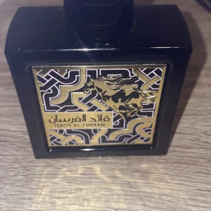 Qaid Al Fursan Parfym - Säljer en elegant och maskulin parfym från Qaid Al Fursan. Flaskan är svart och fyrkantig med en snygg etikett som har ett guld- och svartmönster samt en bild av en häst. Parfymen väger 75ml och är perfekt för den som vill ha en kraftfull och långvarig doft. Köp direkt eller ge prisförslag 💛