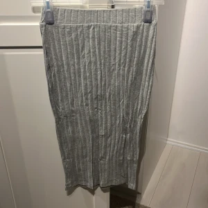Grå ribbad kjol från Shein - En grå ribbad kjol från Shein i storlek S. Kjolen har en tight passform och är tillverkad i ett mjukt och stretchigt material.