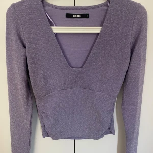 Glitter tröja  - Helt ny tröja från bikbok utan prislapp, endast legat i garderoben & aldrig använd. Syrenlila med glitter, V ringning. 