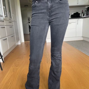 Grunt texas low flare jeans - Svarta/grå Grunt jeans från kidsbrandstore, har ett lagat hål där fram men annars bra skick. Nypris 649kr
