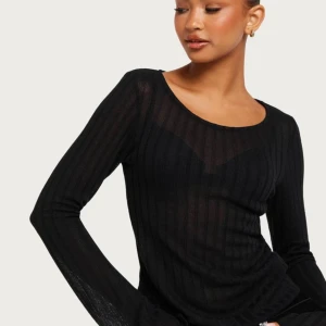 Topp från Nelly - Säljer denna underbara topp från Nelly då den tyvärr inte kommer till användning! Aldrig använd. Ribbat material, passar både S och M beroende på hur man vill att den ska sitta.