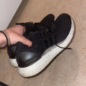 Svarta Adidas Ultraboost sneakers - Säljer ett par svarta Adidas Ultraboost sneakers i storlek 37. Skorna är i bra skick och har en bekväm och stötdämpande sula. Perfekta för både träning och vardagsbruk. Knappt använda och kommer ej till användning pga de ej passar mig!
