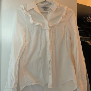 Vit skjorta - Vit skjorta från hm. Använd fåtal gånger. Söt med volang detaljer. 