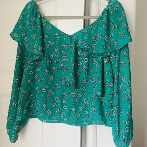 Sommarblus från Gina Tricot - Grön blus med blommor från Gina Tricot. Använd men i fint skick. Köparen står för eventuell frakt. 