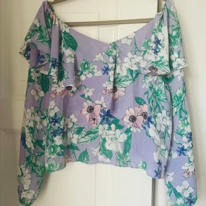 Somrig blus från Gina Tricot - Ljuslila blus med blommor från Gina. Använd men i fint skick. Köparen står för eventuell frakt.