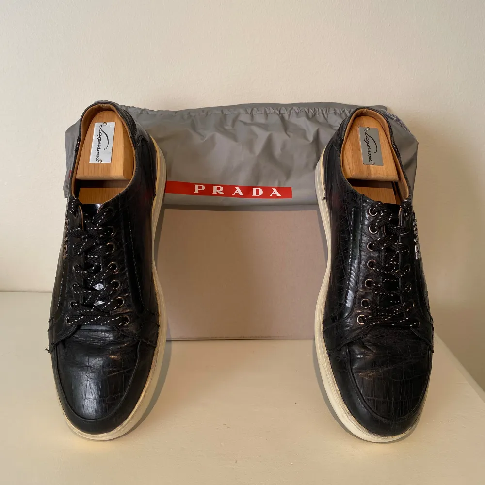 Hej, säljer ett par svarta Prada sneakers i elegant läder. Enormt kvalitativa, bekväma och stilrena. Dustbag medkommer. Använda men i fint skick. Passar till allt & lätta att stylea. Storlek 43. Nypris över 7000kr. Pris kan diskuteras. Hörs i DM! . Skor.