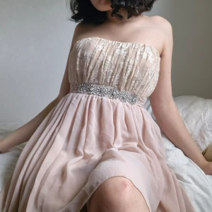 Beige finklänning Elise Ryan  - Supervacker strapless högtidsklänning 🌸 I mycket fint skick. Finns ingen lapp med storlek men passar mig som är S-M. (Skicka ett meddelande för mått) Dragkedja i ryggen, band knyts baktill. Formar fint! Hör av er om ni undrar något! :)