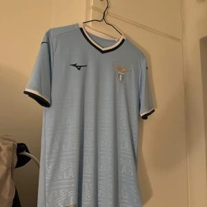 Lazio Hemmatröja 2024/25 - Lazio Hemmatröja för den kommande säsongen 2024/25  Storlek S Äkta med lappen kvar (kvitto finns) Köpt i Lazio shop i Italien och är aldrig använd alltså 10/10 i skick.