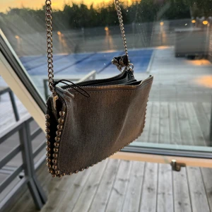 Blå jeans väska  - Fint skick, använd en gång. Säljs pga flytt varav jag måste rensa. Har hårsnoddar på kedjan då jag velat ha den som axelväska, går även att ha i handen och långt över båda axlarna. Nypris 300
