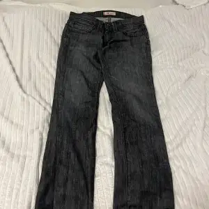 Lågmidjade Levi’s jeans som är mörkgrå/svarta. En rak modell i storlek 26/32 men tyvärr är de försmå för mig. Midjan 40cm och innerbenslängden är 82cm☺️Skriv om du har några frågor💕 Priset ej hugget i sten!