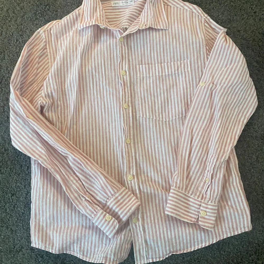 Säljer denna linneskjorta från zara som är väldigt sparsamt använd, den är i storlek 164 så ungefär XS i herr. Den är i färgen vit/rosa.. Skjortor.