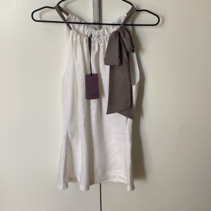 Jätte fint linne ifrån Coast! - Super fint vitt linne med lila/beige knytning ifrån Coast i storlek 8!☺️ Helt oanvänd med prislappen kvar! Originalpris: 650kr