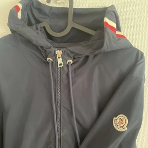 Moncler skaljacka - Säljer min moncler skaljacka (windbreaker) Nyskick inga skador små få tecken på användning men inget som märks Sick:9,9/10 ÄKTA Perfekt till sen sommar eller höst En jacka för livet
