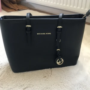 Michael Kors Väska - Hej! Säljer min Michael Kors väska. Den är medel stor och rymmer en del.
