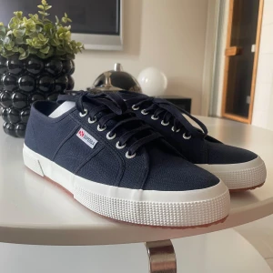 Superga skor marinblå - Skorna är helt oanvända och säljs på grund av att de ej passade! Köpt för 999kr. Storlek 45 men hyfsat små i storleken