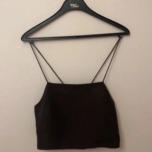 Brun topp - En jätte fin mörk brun topp med snörning på ryggen. Köpt från hm. Nypris 199kr. Fint skick! Är i storleken L men är justerbar och passar S-L!