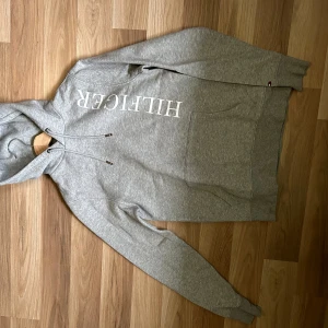 Hoodie - Tommy Hilfiger hoodie Storlek XS Riktigt bra skick men har lagats i ena ärmen(Se bild) Pris kan diskuteras vid snabb affär