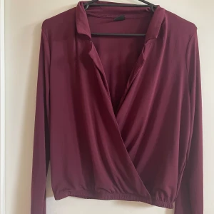 Crossover topp - En vinröd långärmad crossover blus i tunn trikå