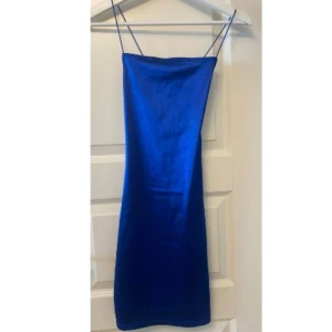 Klänning - Från HM. Använd 1 gång så är i nyskick. Klippt bort lappen men skulle säga att den är i storlek 32/34. Glasigt material och lite djupare i ryggen där banden går i kors. Den är stretchig i materialet. Skriv vid frågor/fler bilder. Pris kan diskuteras❤️