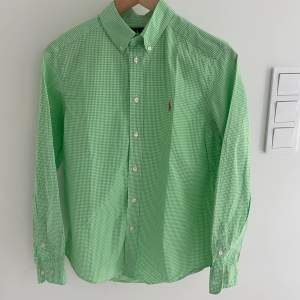 Säljer en snygg grön/vit skjorta ifrån Ralph lauren. Storlek 14-16 år (passar ca 160-165cm. Skjortan är i fint skick! Hör av er vid funderingar.