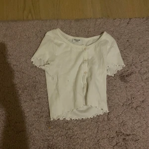 Toppar - Söta toppar från kappahl med knappar framtill, volanger i kanterna, magtröja. En i vitt och en i grönt. Strl 146/152, fint skick, som nya. 