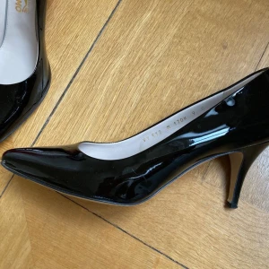 Kitten Heels Pumps SALVATORE FERRAGAMO  - Underbara Kitten Heel Pumps från SALVATORE FERRAGAMO Tillverkade i Italien Storlek: 39.5 Hälhöjd vertikalt mätt ca 6.5 cmEnkel, elegant och tidlös Superskön att bära! Lackläder i tidlöst svartAnvänds en gång, mycket gott skick, med låda, dammpåse och