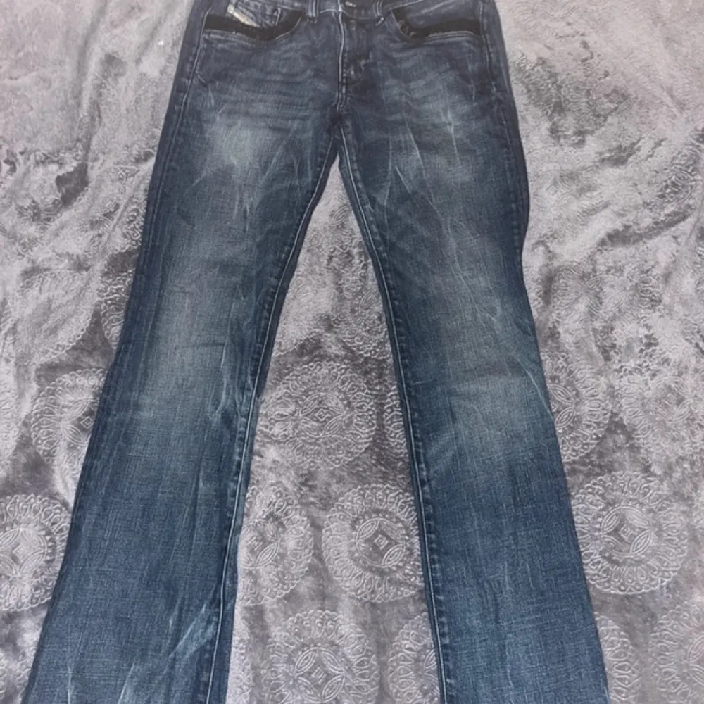 Ett par low waisted diesel jeans med utsvängda ben som har paljettdetaljer på bakfickorna och framfickorna. Jeans & Byxor.