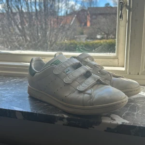 Adidas stan smith - Adidas stan smith skor med kardborreband, jätte gulligt kardborre skor med gröna detaljer. (Tvättas innan jag postar dom) köpte från adidas hemsidan för 1099kr. Dom är i storlek 39, pris kan såklart diskuteras!😀
