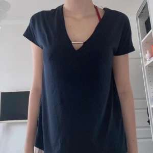 Kortärmad blus - En mörkblå blus som är kortärmad och är v-ringad med en fin detalj i mitten