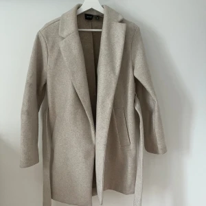 Beige kappa - En beige kappa från vero  moda. 