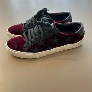 Svincoola och unika Saint Laurent sneakers i vinröd sammet med svarta stjärnor på. Väldigt bra skick då dom endast använts under en sensommar/höst-period. Passar perfekt på mig som har 37/38 i skor! Nypris:6800