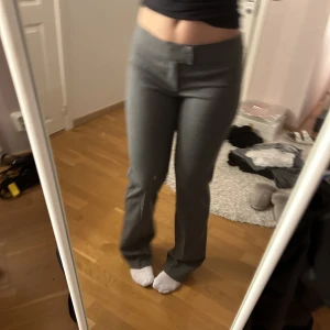 Lågmidjade kostymbyxor - Ett par grå lågmidjade kostymbyxor från Nelly. Storlek 36. 