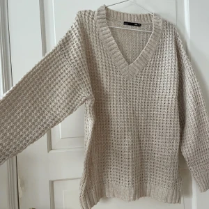Stickad tröja - Hålstickad v-ringad tröja från Lager 157. Oversized. Storlek M. Krämvit/beige. Använd en gång, i fint skick. Bara att fråga om det är något du undrar! Kan mötas på Järntorget i Göteborg eller skicka, köparen står för frakt.