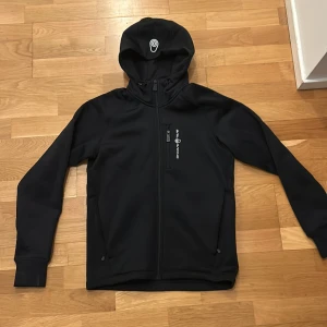 Sail racing spray powerstretch zip Hood  - Sail racing fleece tröja, helt oanvänd Inga defekter. Varm och skön och väldigt bra kvalitet.  Original pris 2000kr köpt från Sail racings hemsida