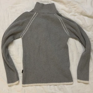 GRÅ CARDIGAN - Små vita målarfärgprickar på som det syns i bilderna. Går att få bort med nageln om man orkar. Säljs för att det inte är min stil.