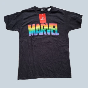 Marvel t shirt - En regnbågig marvel t shirt som jag köpt i en butik i münchen men tyvärr aldrig använt. Lappen sitter kvar. Den är från marvels pride collection 2022, så den säljs inte i butik längre, nypris var runt 270kr.