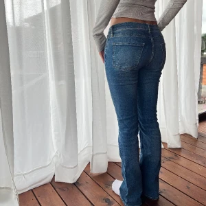 Lowwaist - Lowwaist utsvängda jeans med stretch. Midjemått: 36cm Innerbenslängd: 79cm Fraktkostnad tillkommer.