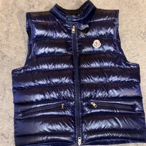 Moncler gui väst  - Moncler gui väst äkta. Ett litet hår på ryggen (laggat) Den är marin blå.  Kan prutas Kan även bytas mot allt möjligt bara skriva😁