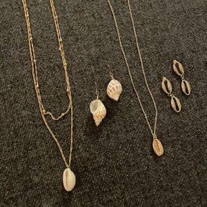 2set med halsband o örhängen - 2 ser med halsband o örhängen. Guldfärgade båda två. Med två olika sorters snäckor