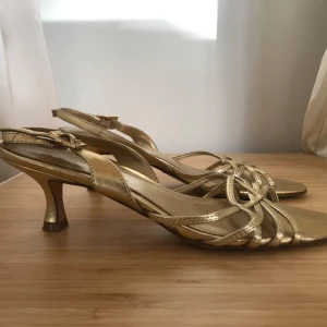 Kitten heels - Snygga låga klackar från märket ”Predictions” som tyvärr inte kommer till användning 🤍 Guldiga med strass på ankelremmen. Perfekta till bal eller studentfest. Storlek 7, skulle säga 37-38.  Skriv ifall du har frågor!